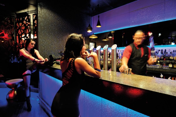 Imbibing other spirits, Calendar Girls Roxy and Storm grab a pre-performance drink in the upstairs bar of the exclusive strip club. The club has been operating inside the 118-year old Naval and Family Tavern building on the corner of K’ Road and Pitt Street since 2011. 