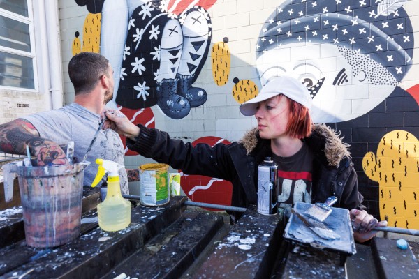 132_streetwise_bodyimage5 In Auckland, street artist and tattooist Tom ‘TomTom’ McMillan works on a piece made in collaboration with multimedia artist Misery (Tanja Jade), one of five murals painted by nine artists over two days as part of the second Bradley Lane Mural Project in Glen Innes.