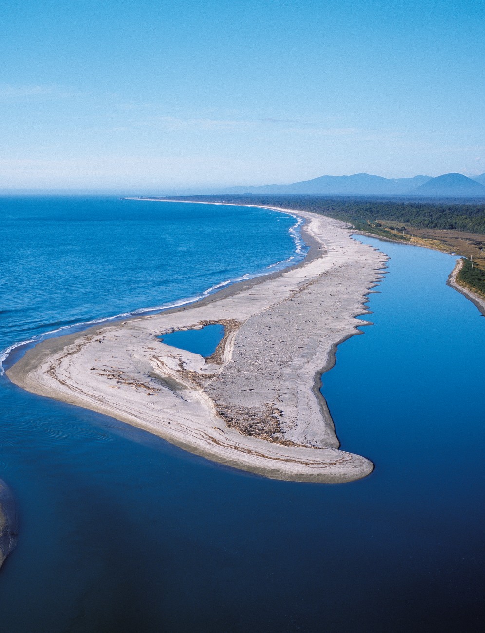 On a calm day the Waiatoto mouth looks benign, but after every large storm, more debris pours into the bay and the configuration of the river entrance may change substantially—just part of the interest in living in a place like Haast.