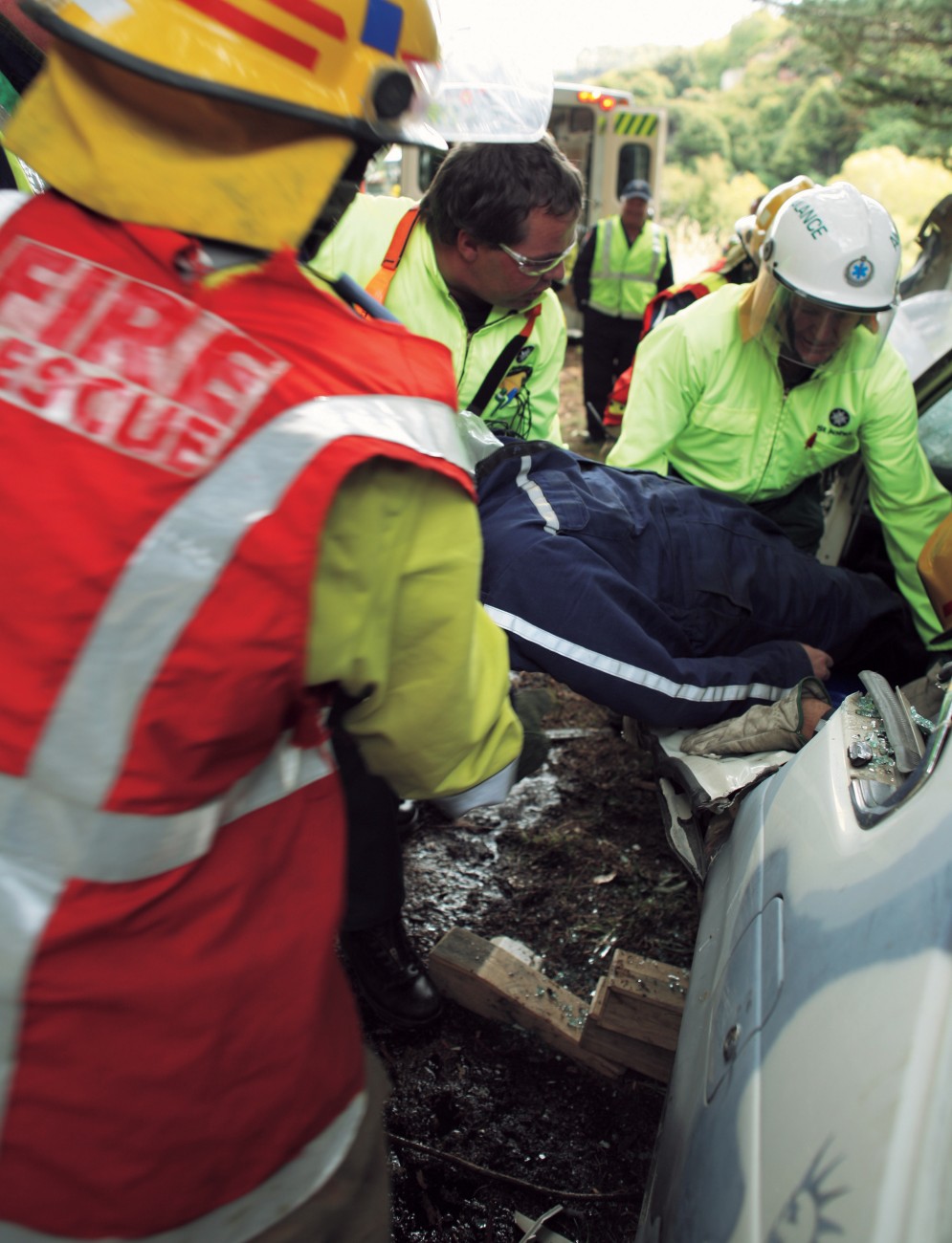 A St John crew work their way into a vehicle as soon as the fire and rescue team have secured safe access and cleared any obstacles to extracting the injured person. Time is always critical for car-crash victims—the odds of survival are greatly enhanced by a speedy rescue.