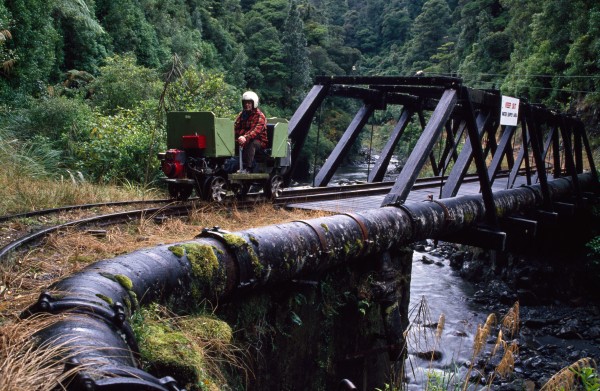 Wellington draws its water from rivers and reservoirs in the hills surrounding the city. At Wainuiomata, caretakers use a private railway to check a pipe that takes water from the Orongorongo River, through a three-kilometre tunnel and into a dam in the adjacent valley. Auckland's water also comes from a surface catchment, with reservoirs located in the Waitakere and Runua Ranges. In winter, excess water turns the spilllway of the Lower Nihotupu dam in Huia (one of the smaller reservoirs) into a bridal veil of cascading droplets.