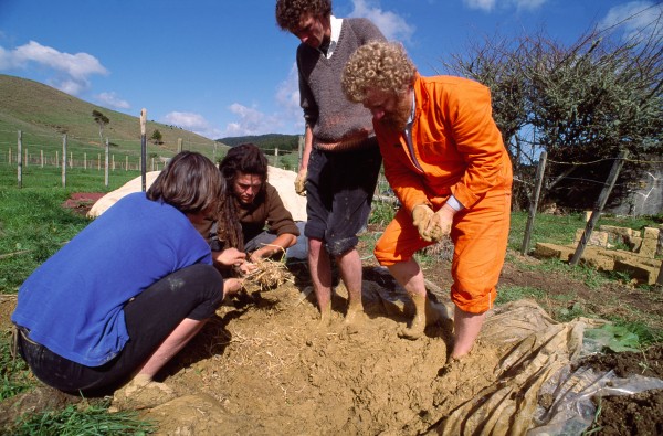 A modern variant of sundried brick is pressed brick, a mixture of soil and cement which is pressed into a uniform shape by machine. Nick Parker of Auckland used this type of brick for a winery on Waiheke Island (above). Nelson, with its reputation as the sunniest place in New Zealand, is an ideal site for Ralph Butcher's adobe brick yard. In summer, his bricks take just two weeks to fully dry, and he can turn out 6000 a month. Earth entImsiast Graeme North (orange overalls, below), a Warkworth architect and chairperson of the Earth Building Association of New Zealand, regularly teaches the finer points of treading adobe by having his students roll up their trousers and get stuck in.