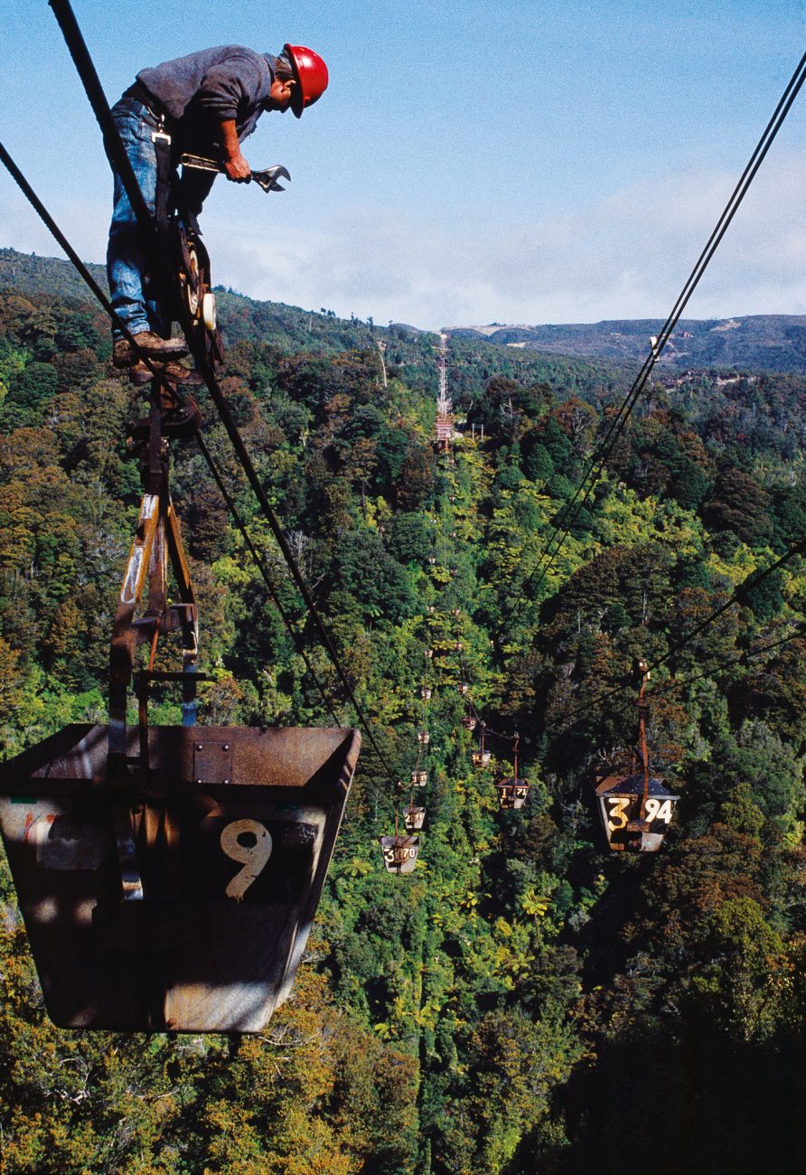 Poised like a trapeze artist, Dave Reed checks pulleys on one of 368 buckets that unceasingly lug coal from the huge mountaintop mine at Stockton over 7.7 km of hills to the railhead at Ngakawau.