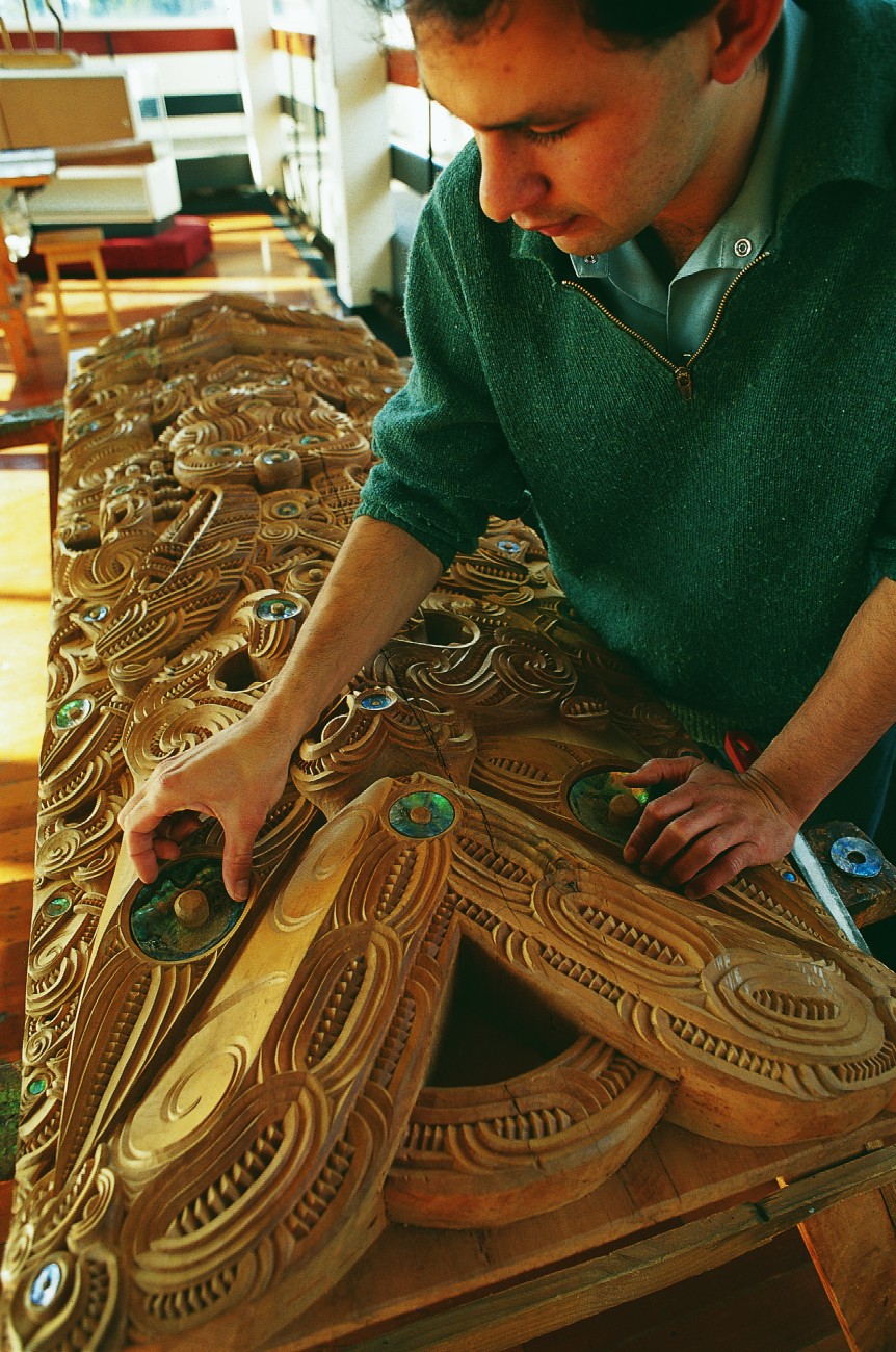 Maori have long valued the flash of paua shell to emphasise the life of carved ancestors in the gloom of the meeting house. Here Nathan Foote, a trainee carver at the NZ Maori Arts and Crafts Institute in Rotorua, checks fits the eye to his masterpiece.