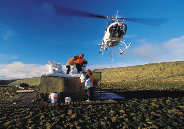 58_CampbellIsland_body04 Hovering to one side of a loading station in case of mechanical failure, a Jet Ranger waits as ground crew scramble to refill its spreader bucket with bait. A respectable time to empty ten 30 kg bags into the bucket was 15 seconds.