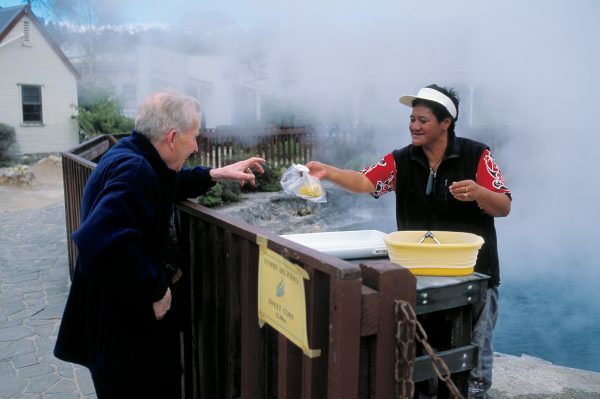 65_MtTarawera_16 Whakarewarewa Maori still use thermal pools to cook food—though these days it is more as a novelty than out of necessity. Here Tiarangi Morgan sells a visitor a cob of sweetcorn boiled in the Champagne Pool behind her, which is 100°C at the surface. Maori known the pool as Parekohuru, which translates as Murderous Ripples.