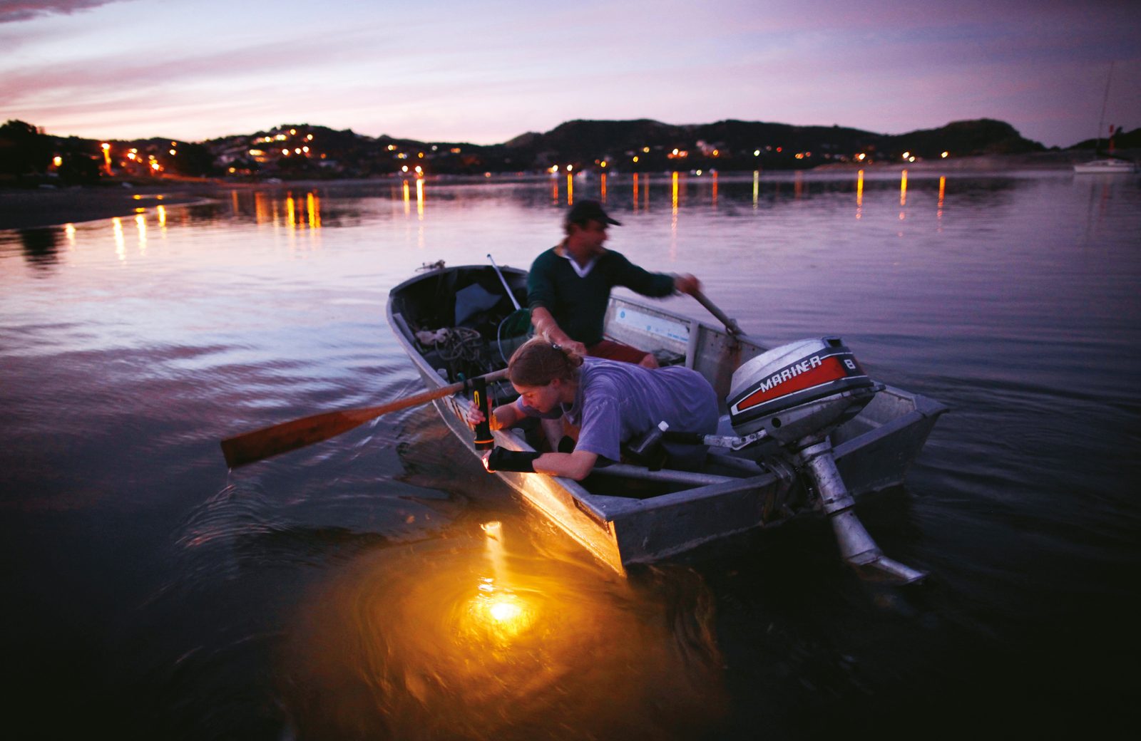 Rachel Lowrie peers into the Mangawhai estuary as her stepfather Michael Brown rows towards the township after their outboard motor broke down at the end of a day’s fishing. 