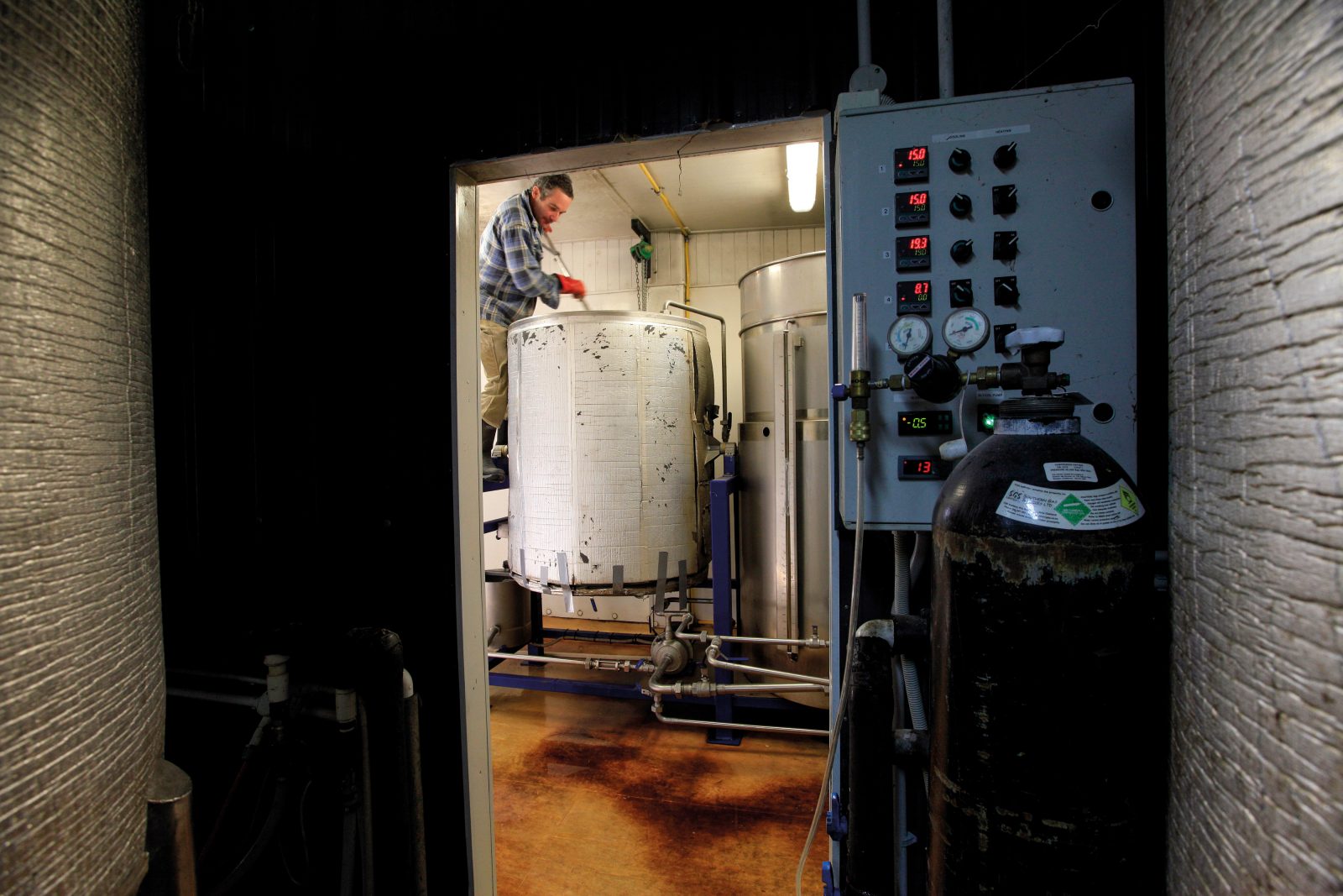 Martin Townsend breaks up lumps of freshly milled malt in the mash tun using a beater in a battery-powered hand drill.